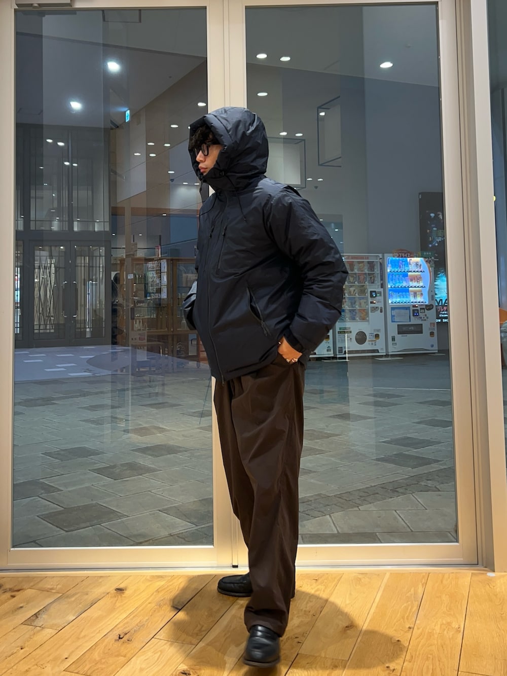 ブラウン系のその他パンツ、ブルー系のダウンジャケット/コートを着用したメンズの秋コーディネートの2枚目の写真