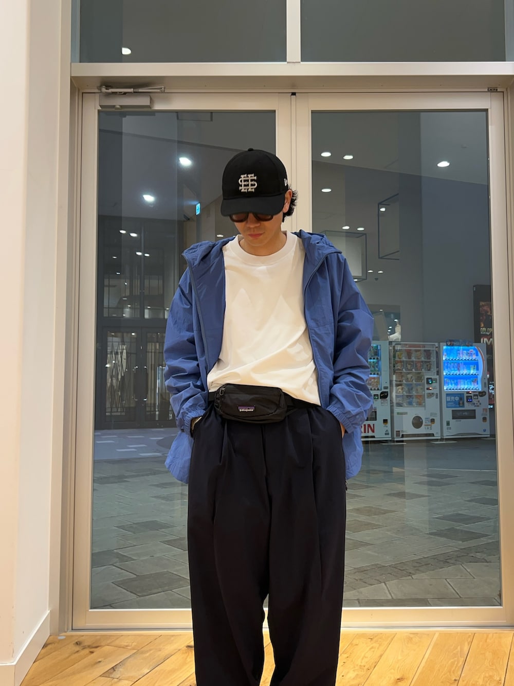 ブルー系のナイロンジャケット、ブルー系のその他パンツ、ホワイト系のTシャツ/カットソーを着用したメンズの春コーディネートの2枚目の写真