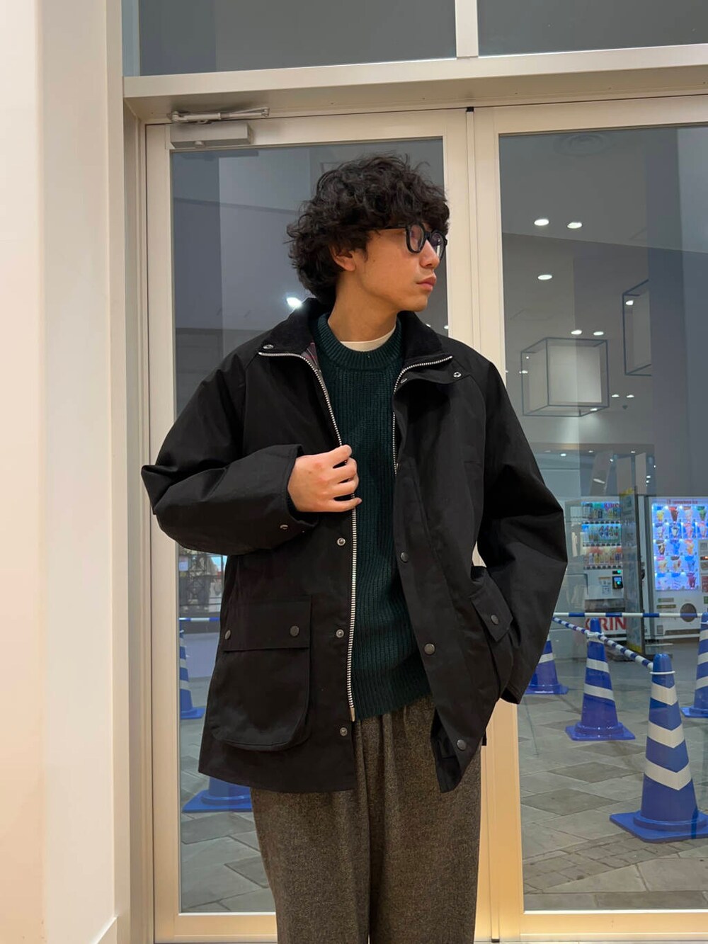 グリーン系のニット/セーター、グレー系のその他パンツ、ブラック系のその他アウターを着用したメンズの冬コーディネートの3枚目の写真