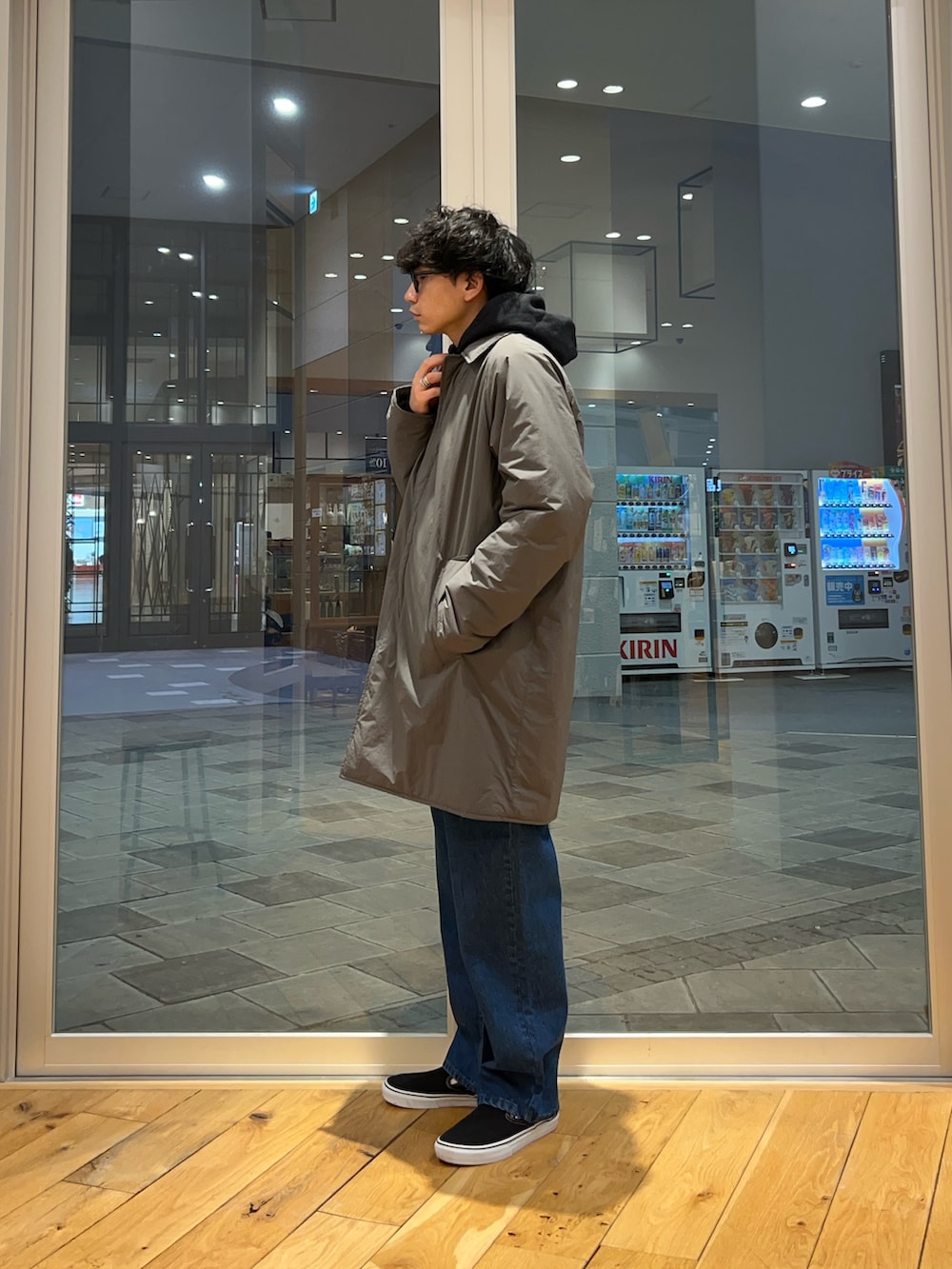 ブラック系のパーカー、ブルー系のデニムパンツ、グレー系のその他アウターを着用したメンズの冬コーディネートの2枚目の写真