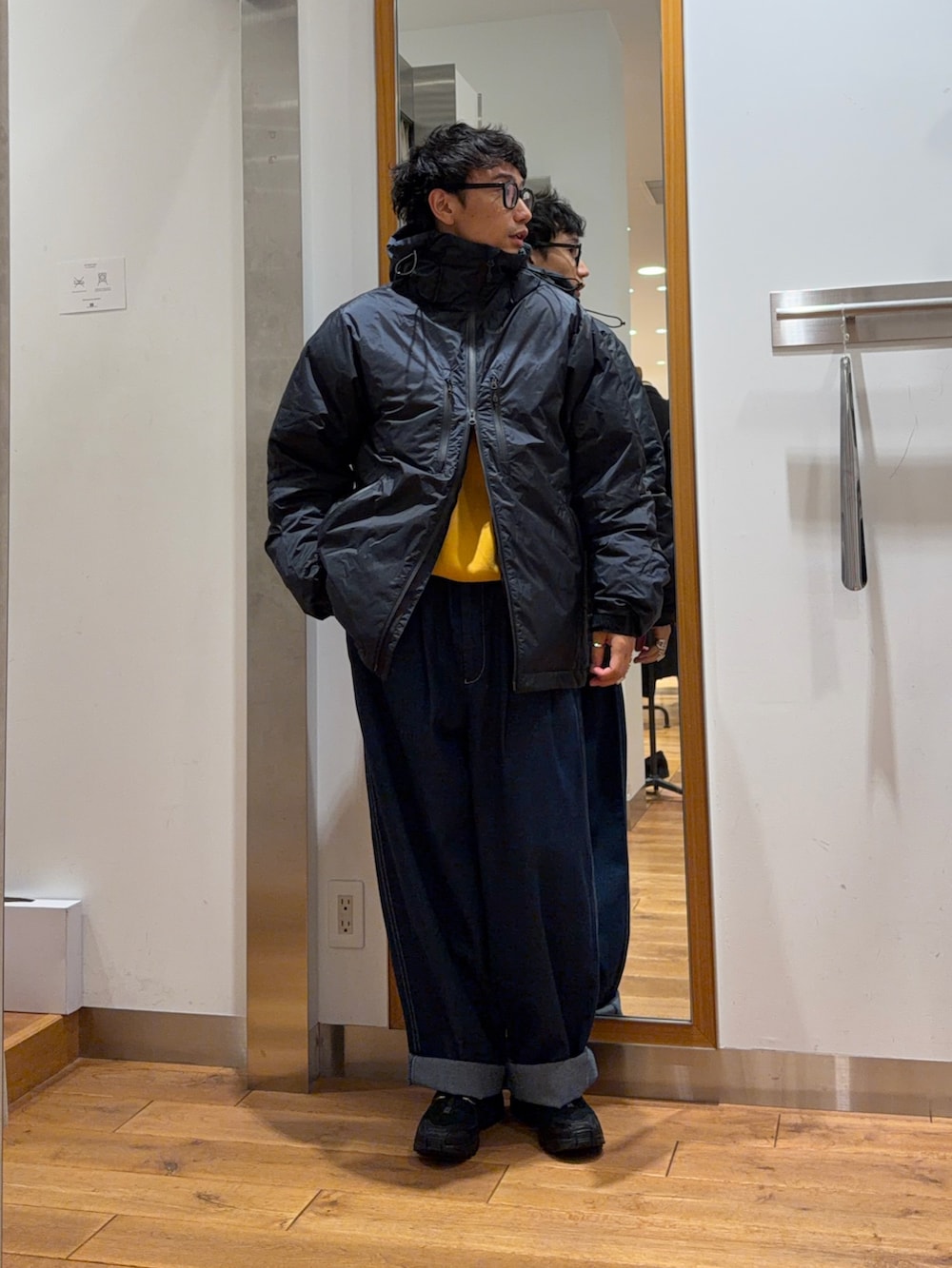 イエロー系のスウェット、ブルー系のその他パンツ、ブラック系のダウンジャケット/コートを着用したメンズの秋コーディネートの2枚目の写真