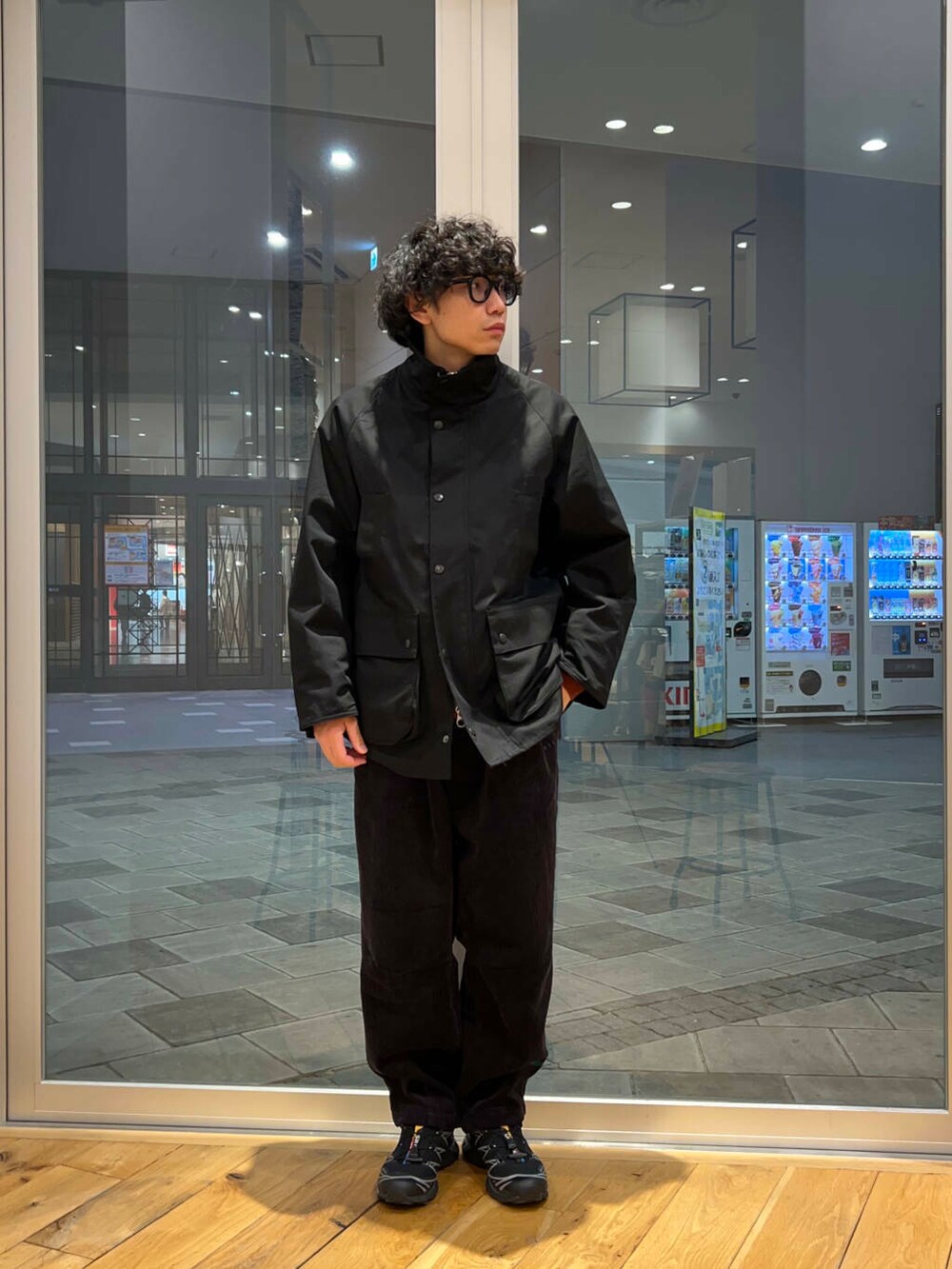 グレー系のその他パンツ、オレンジ系のニット/セーター、ブラック系のその他アウターを着用したメンズの冬コーディネートの3枚目の写真