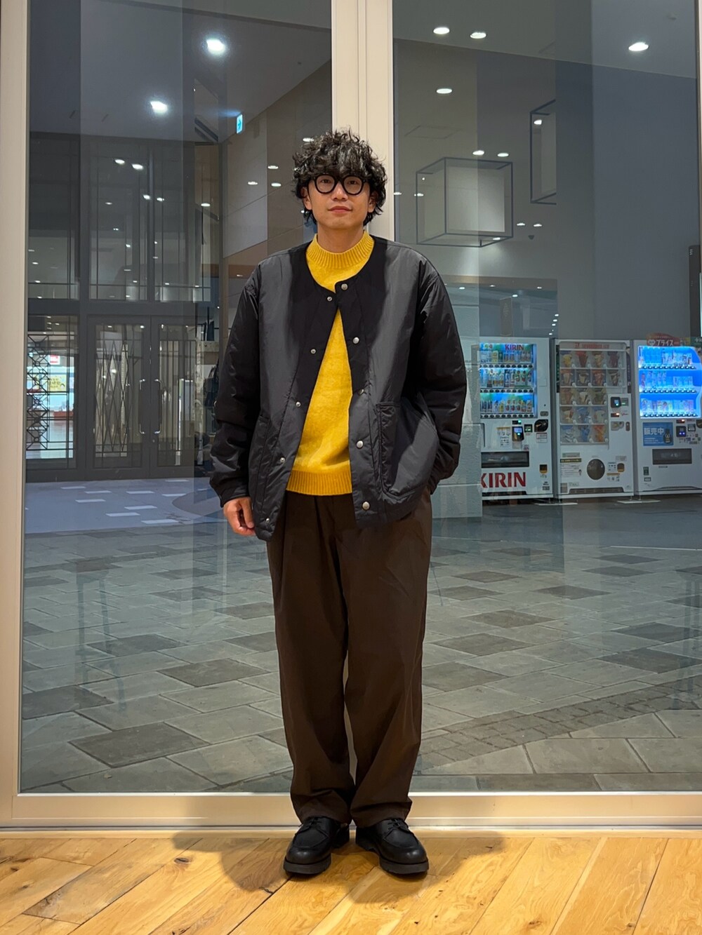 ブラック系のブルゾン、ブラウン系のその他パンツ、イエロー系のニット/セーターを着用したメンズの冬コーディネートの2枚目の写真