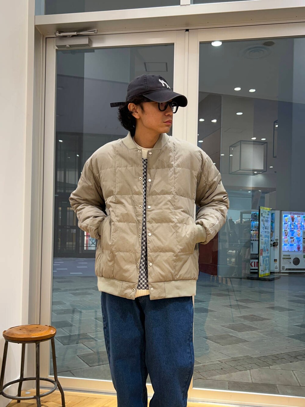 ブルー系のデニムパンツ、ホワイト系のニット/セーター、グレー系のダウンジャケット/コートを着用したメンズの冬コーディネートの3枚目の写真