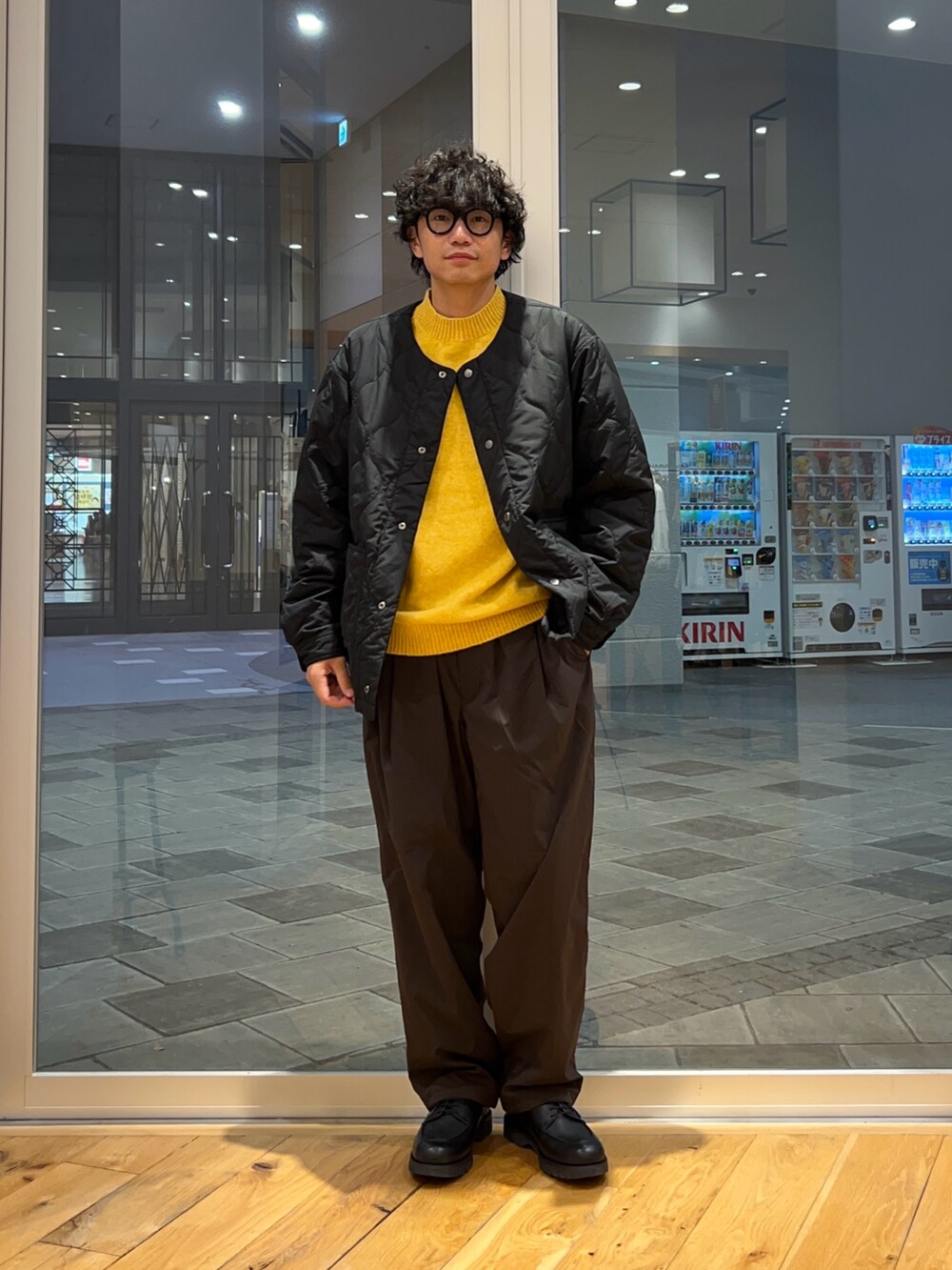 ブラック系のブルゾン、ブラウン系のその他パンツ、イエロー系のニット/セーターを着用したメンズの冬コーディネートの4枚目の写真