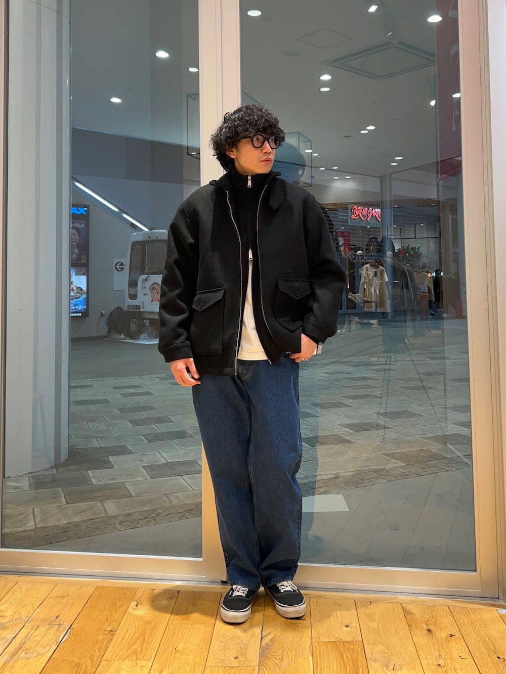 ブルー系のデニムパンツ、ブラック系のニット/セーター、ブラック系のその他アウターを着用したメンズの冬コーディネートの3枚目の写真