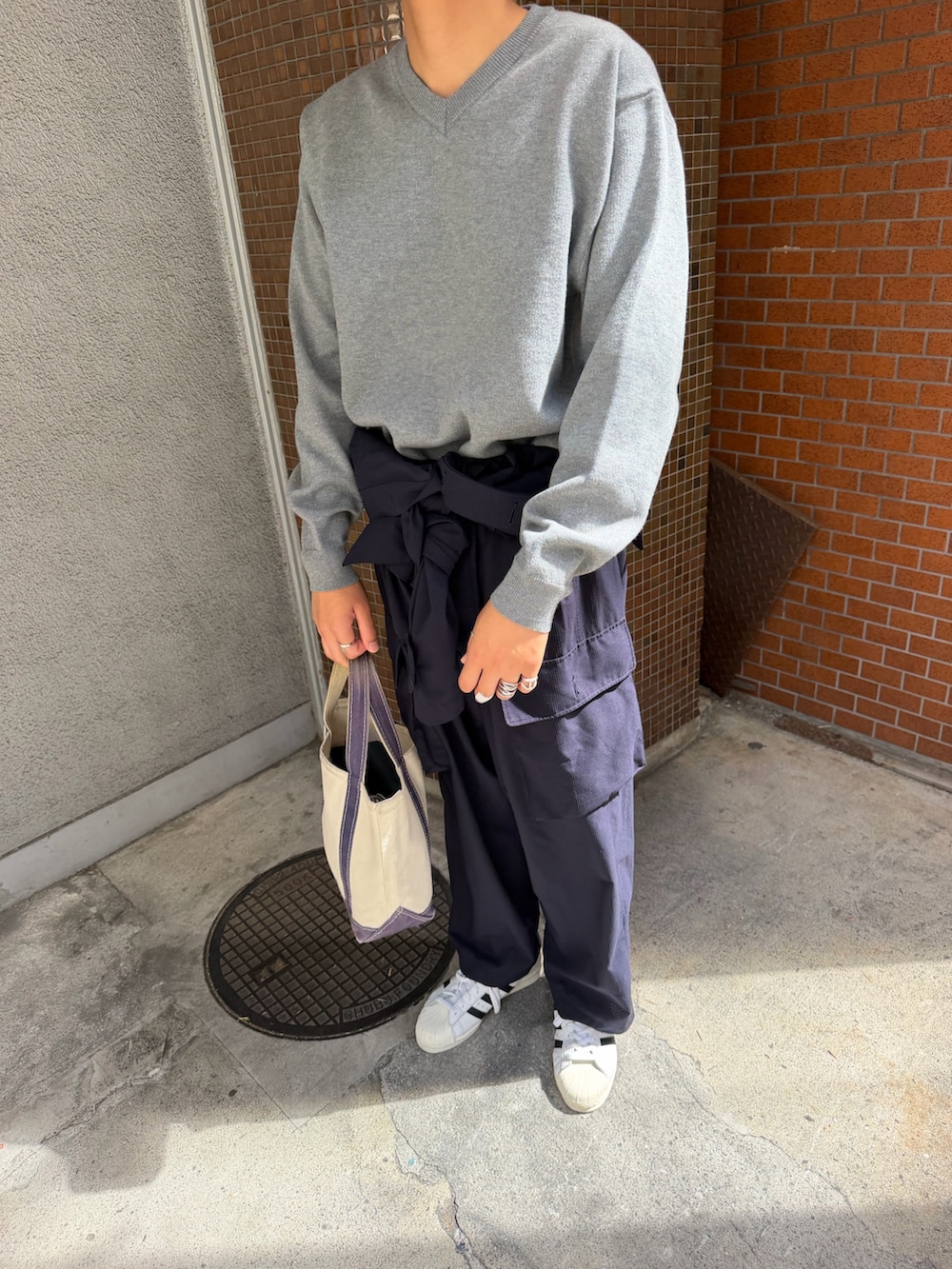 グレー系のニット/セーターを着用したメンズの秋コーディネートの2枚目の写真