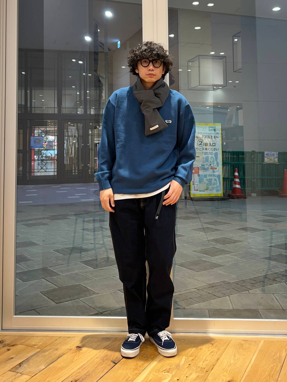 ブルー系のデニムパンツ、ブルー系のニット/セーター、グレー系のマフラーを着用したメンズの秋コーディネートの2枚目の写真