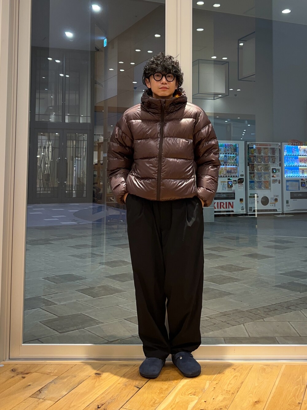 ブラウン系のダウンジャケット/コート、ブラック系のその他パンツ、グレー系のニット/セーターを着用したメンズの秋コーディネートの2枚目の写真