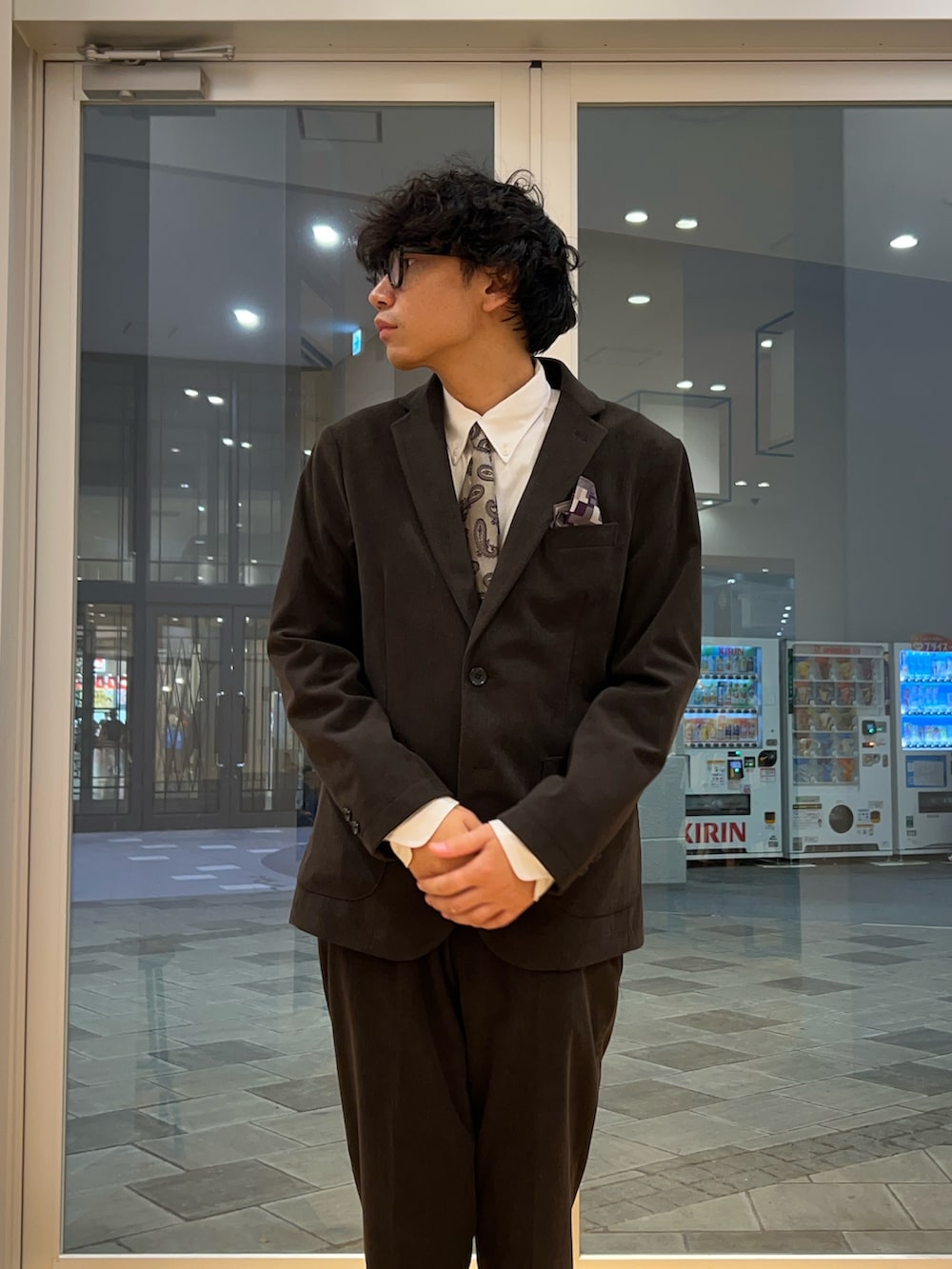 ブラウン系のスーツジャケット、ブラウン系のスーツパンツ、ベージュ系のネクタイを着用したメンズの秋コーディネートの2枚目の写真