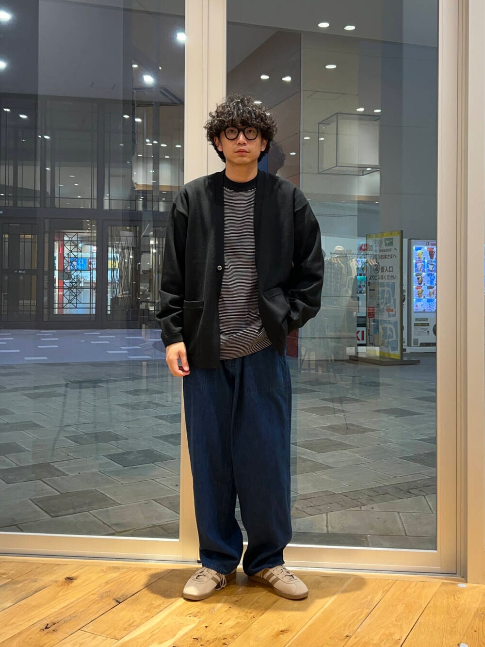 ベージュ系のスニーカー、ブルー系のデニムパンツ、ブラック系のTシャツ/カットソーを着用したメンズの秋コーディネートの2枚目の写真