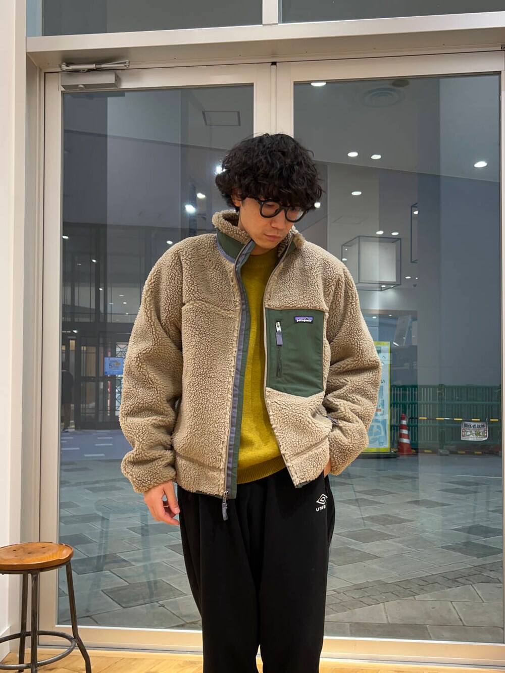 イエロー系のニット/セーター、ブラック系のその他パンツ、ベージュ系のテーラードジャケットを着用したメンズの冬コーディネートの2枚目の写真