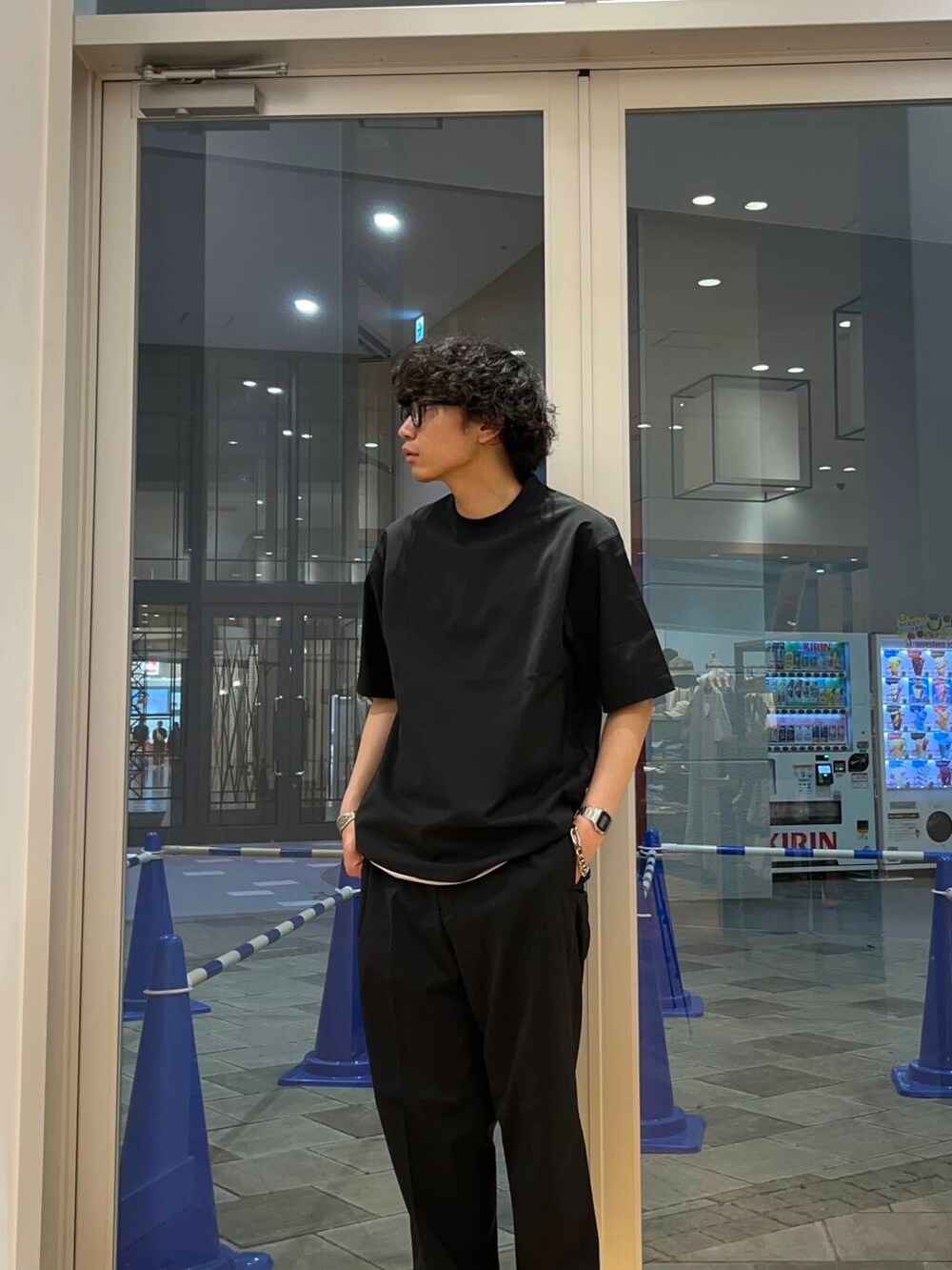 ブラック系のTシャツ/カットソー、グレー系のサンダル、ブラック系のその他パンツを着用したメンズの春コーディネートの2枚目の写真