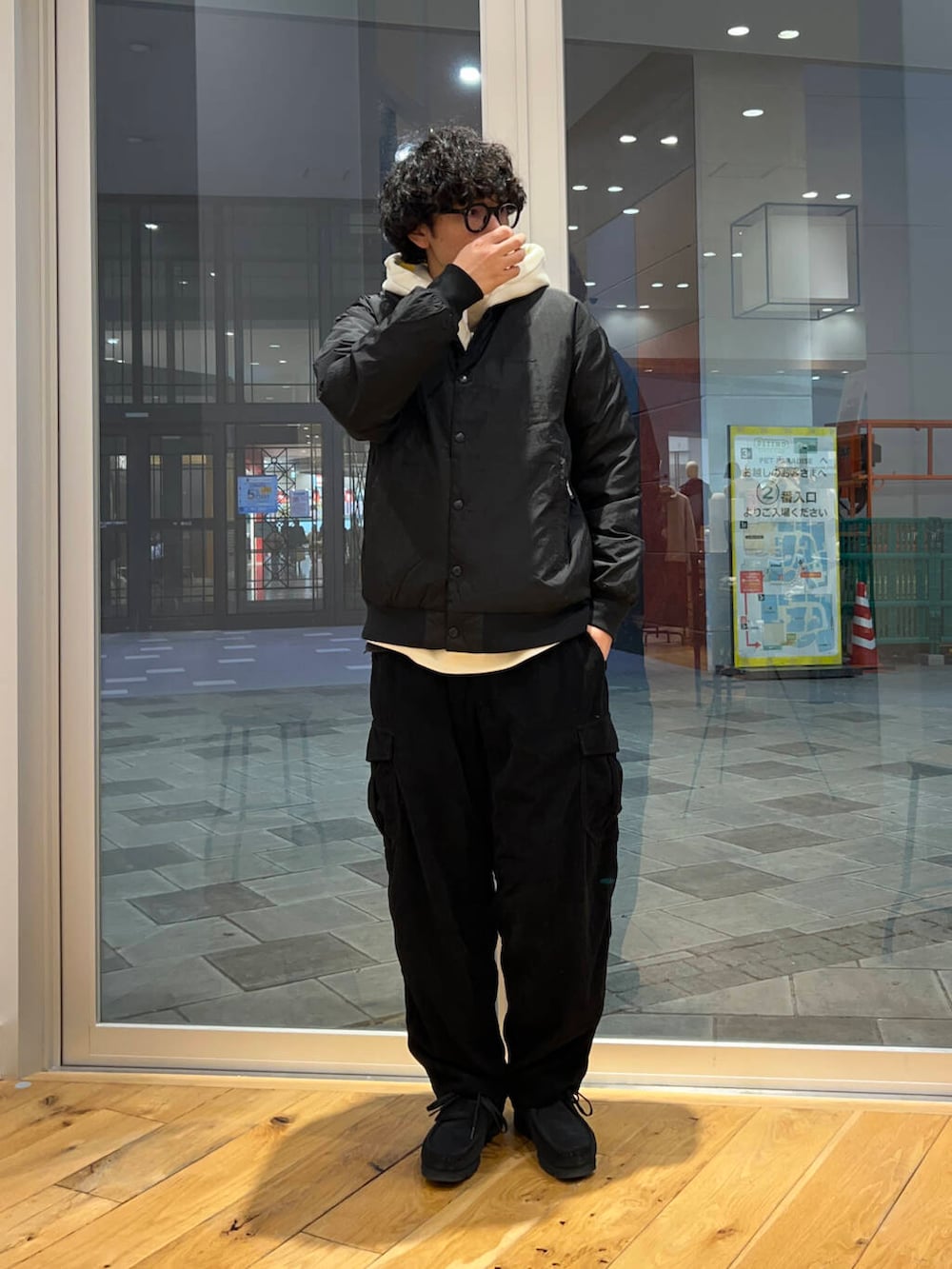 ブラック系のブーツ、ブラック系のダウンジャケット/コート、ホワイト系のパーカーを着用したメンズの秋コーディネートの2枚目の写真