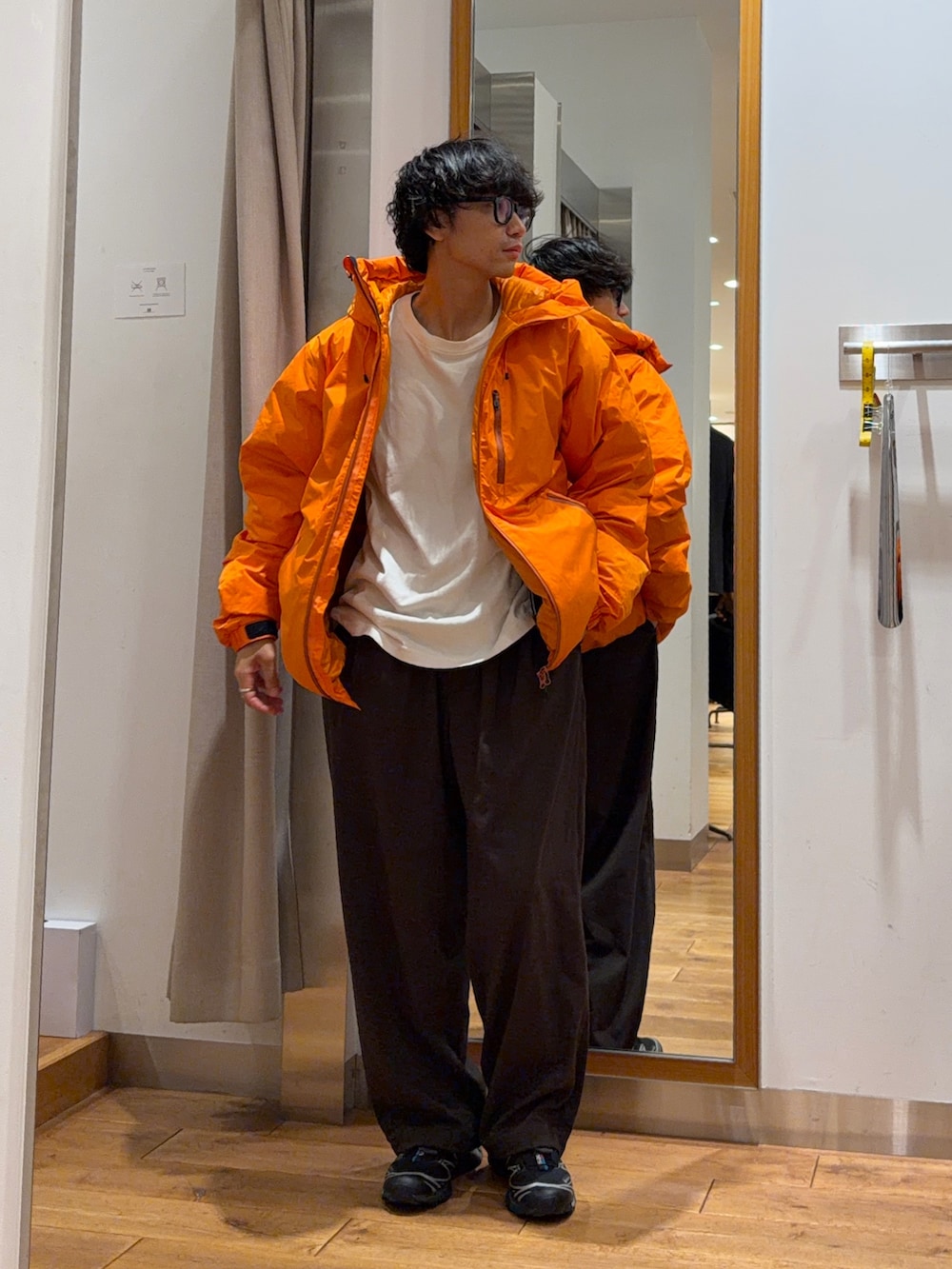 ブラウン系のその他パンツ、オレンジ系のダウンジャケット/コート、ブラウン系のキャップを着用したメンズの秋コーディネートの4枚目の写真