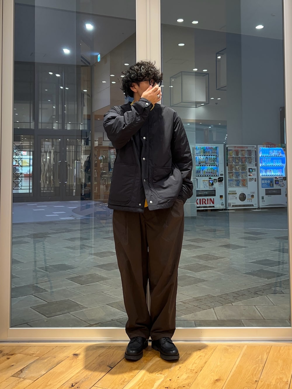 ブラック系のブルゾン、ブラウン系のその他パンツ、イエロー系のニット/セーターを着用したメンズの冬コーディネートの3枚目の写真