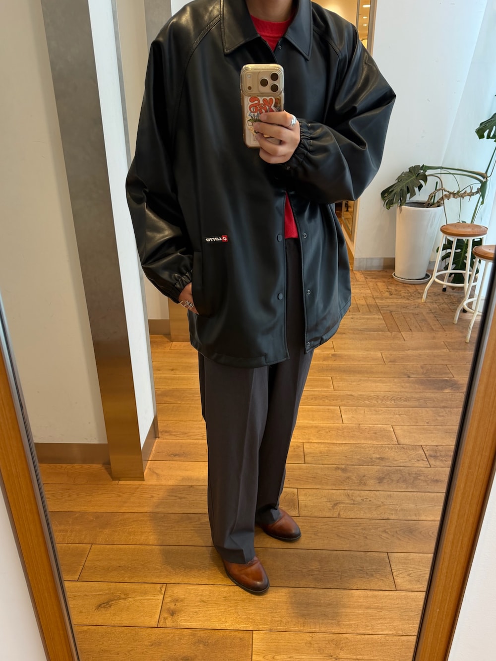 ブラック系のその他アウター、レッド系のニット/セーター、グレー系のその他パンツを着用したメンズの秋コーディネートの2枚目の写真