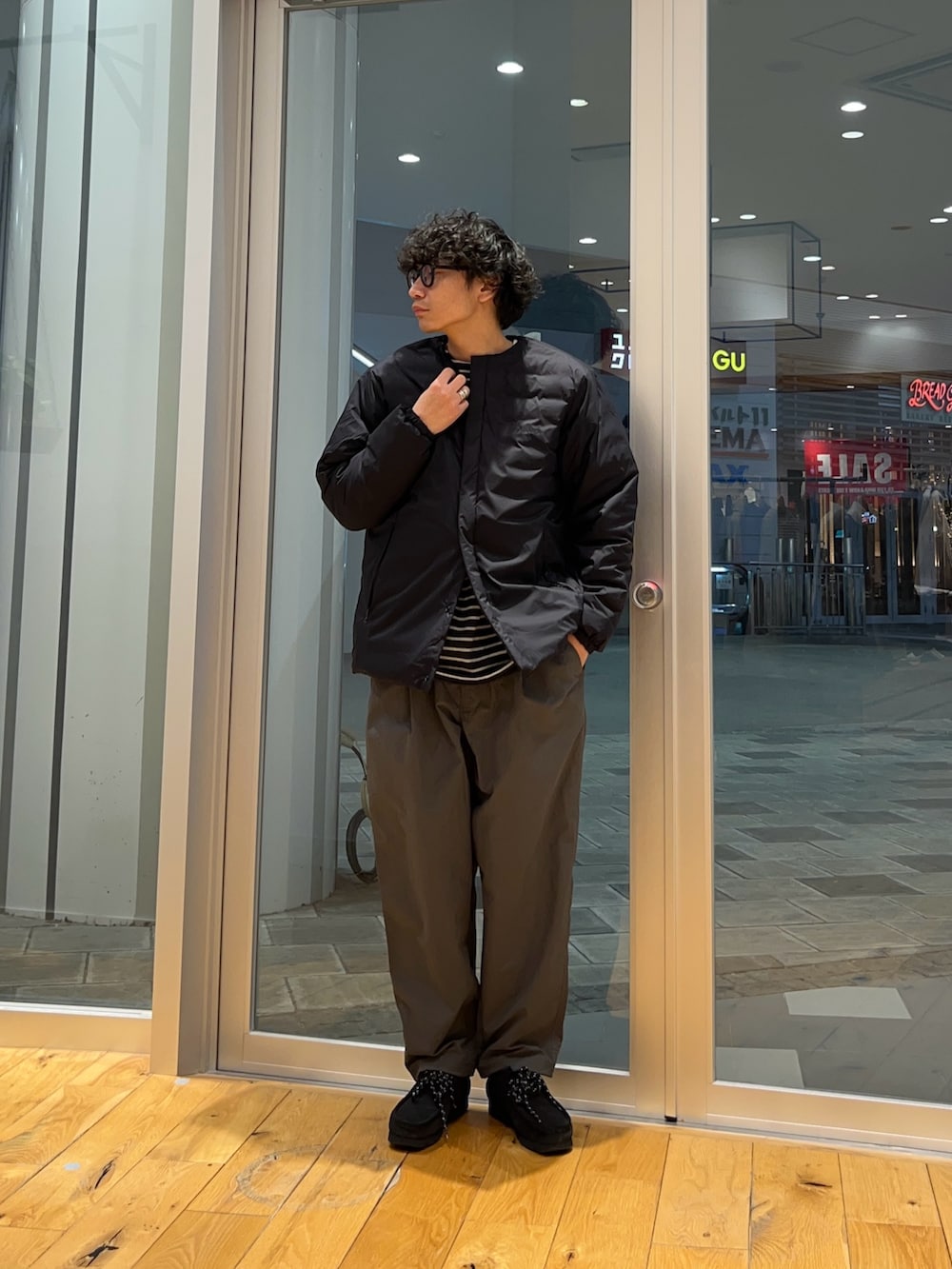 グレー系のその他パンツ、グレー系のTシャツ/カットソー、ブラック系のダウンジャケット/コートを着用したメンズの冬コーディネートの2枚目の写真