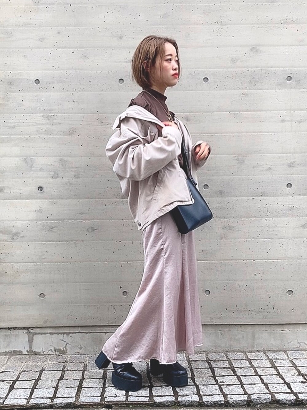 ピンク系のスカート、ブラウン系のトップスを着用したレディースの秋コーディネートの2枚目の写真