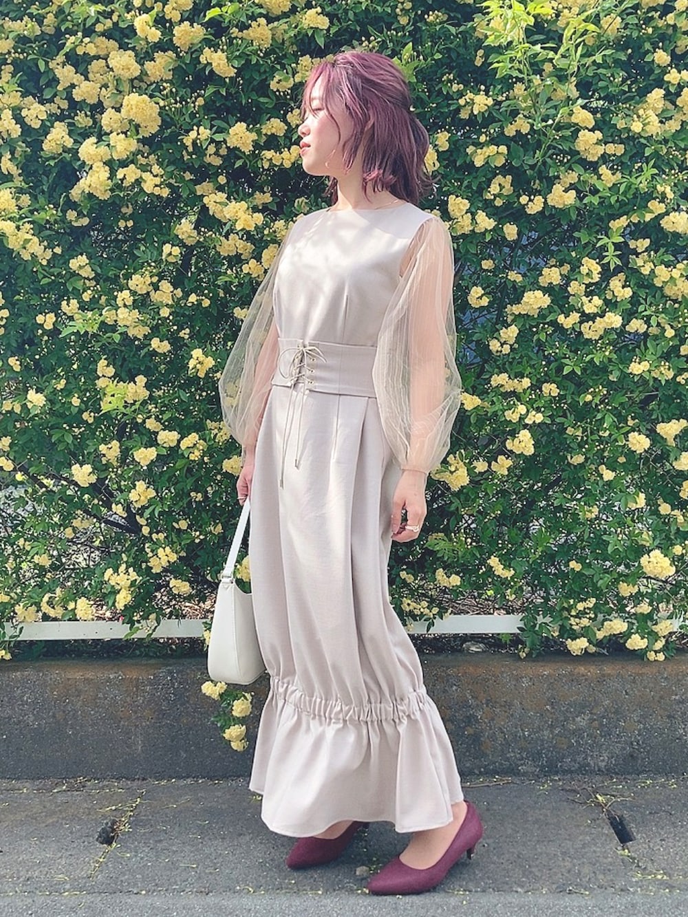 ベージュ系のワンピースを着用したレディースの春コーディネートの2枚目の写真