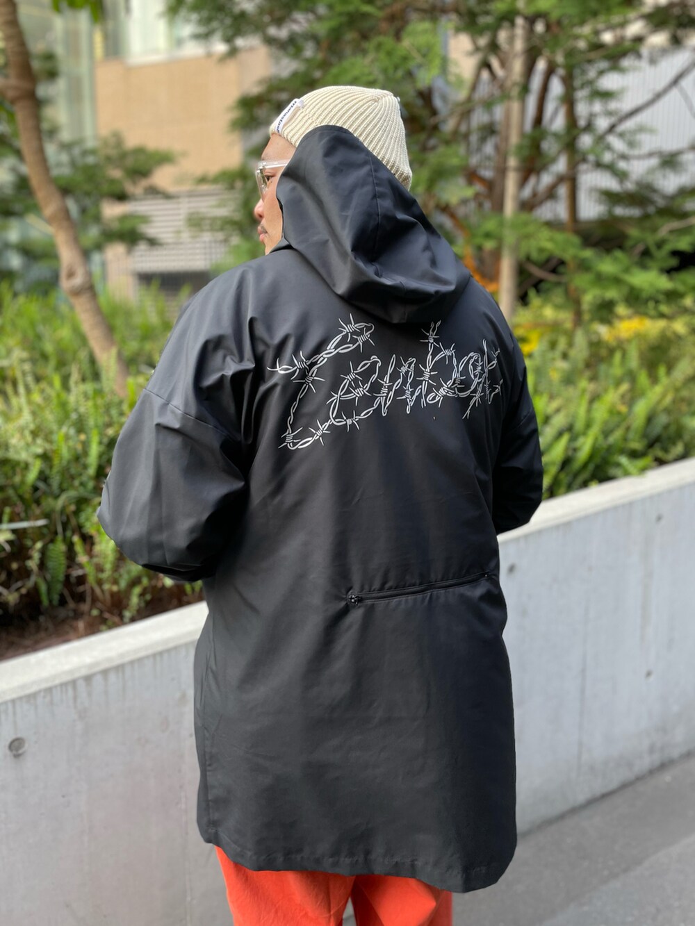 ブラック系のジャケット/アウター、オレンジ系のその他パンツ、ブラック系のサンダルを着用したメンズの春コーディネートの2枚目の写真