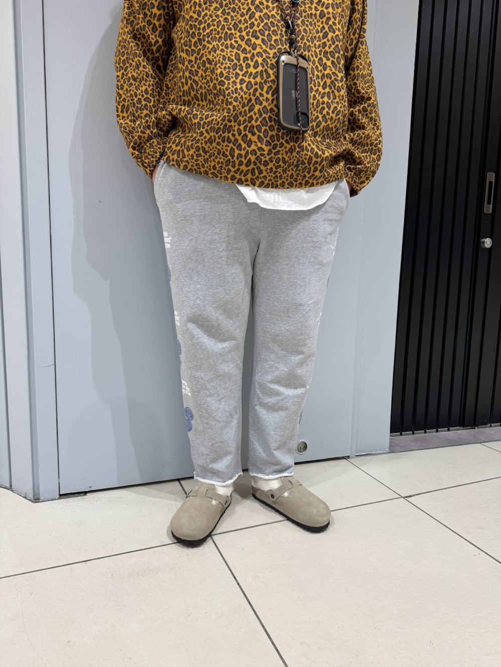 ブラウン系のブルゾン、グレー系のスウェットパンツ、ベージュ系のサンダルを着用したメンズの秋コーディネートの3枚目の写真