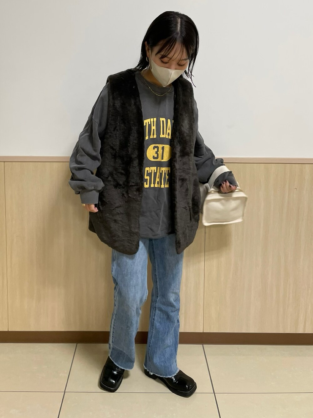 グレー系のベストを着用したレディースの秋コーディネートの2枚目の写真