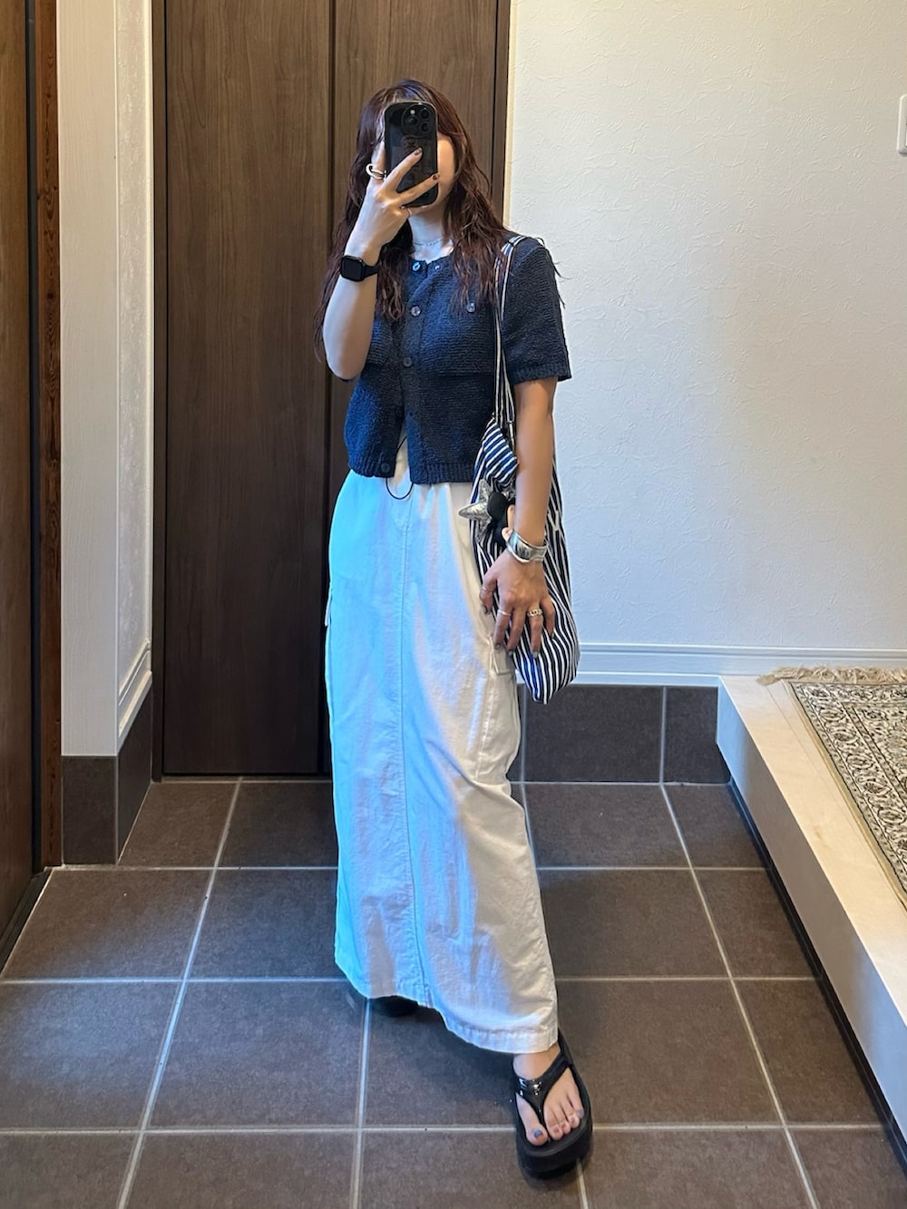 ブルー系のカーディガン/ボレロ、ホワイト系のスカート、ブラック系のサンダルを着用したレディースの夏コーディネートの2枚目の写真