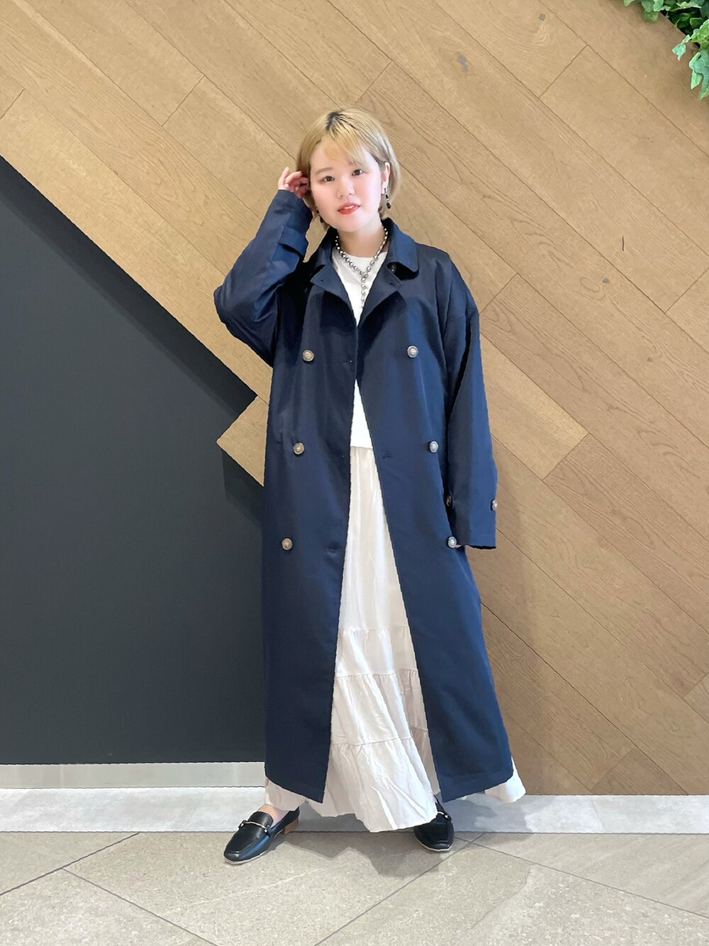 ブルー系のステンカラーコート、その他のTシャツ/カットソー、ベージュ系のスカートを着用したレディースの冬コーディネートの3枚目の写真