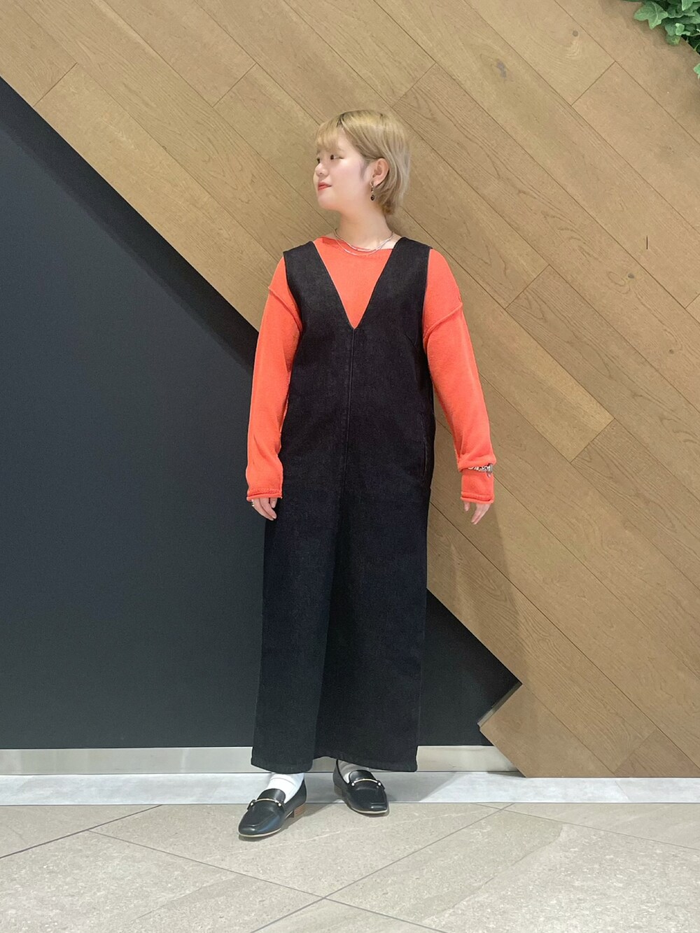 ピンク系のニット/セーター、ブラック系のジャンパースカート、ブラック系のローファーを着用したレディースの冬コーディネートの4枚目の写真