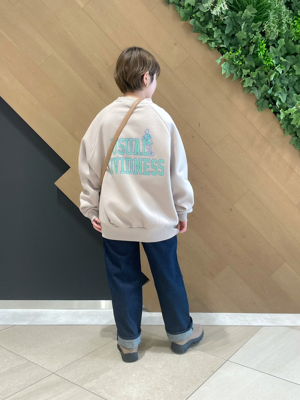 ベージュ系のスウェット、ブルー系のその他パンツ、ベージュ系のブーツを着用したレディースの冬コーディネートの2枚目の写真