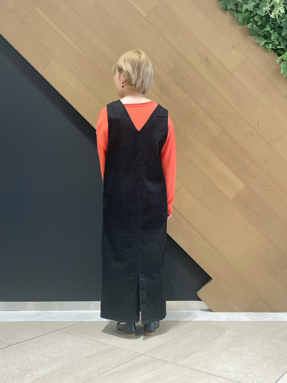 ピンク系のニット/セーター、ブラック系のジャンパースカート、ブラック系のローファーを着用したレディースの冬コーディネートの2枚目の写真