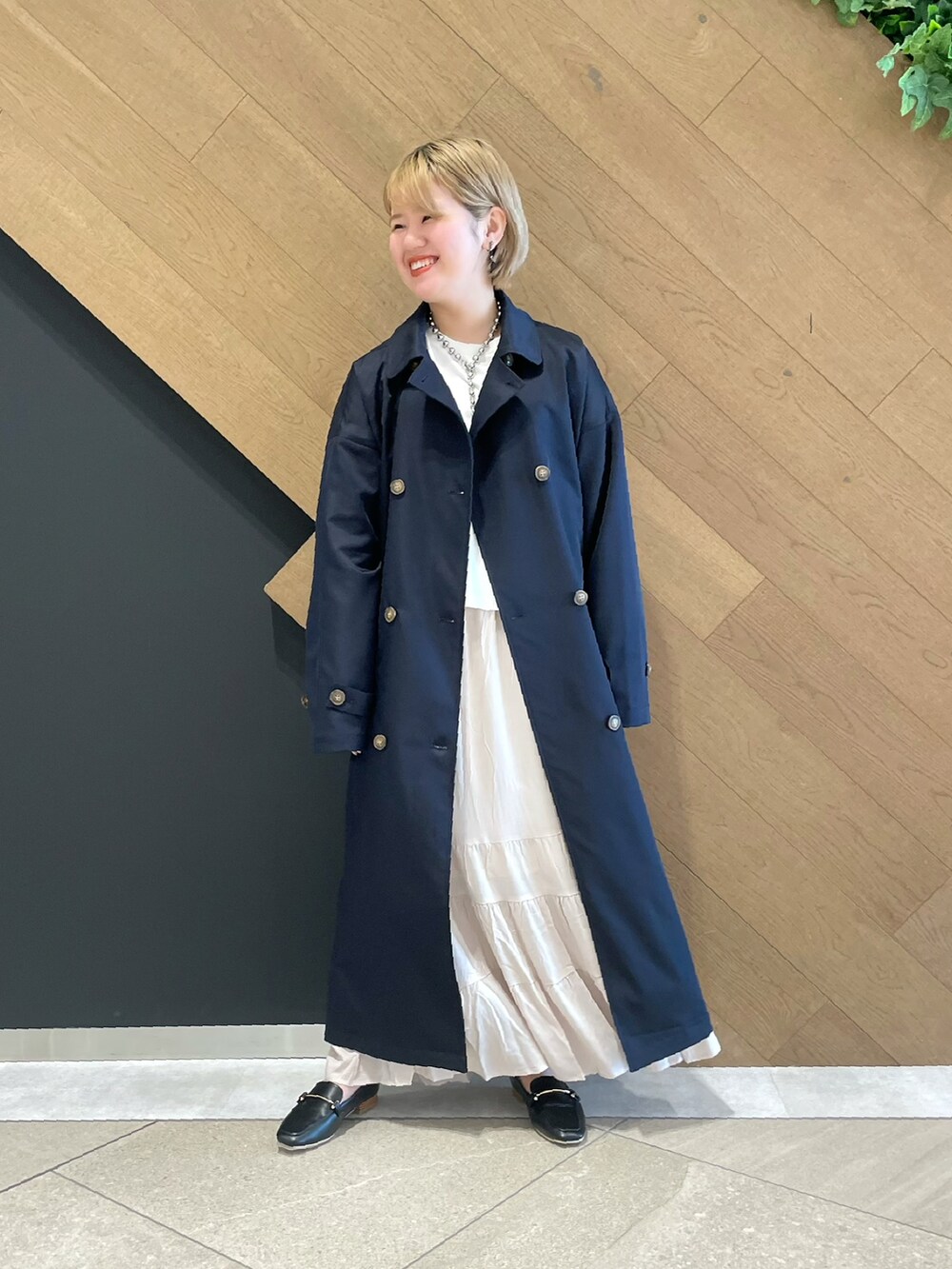 ブルー系のステンカラーコート、その他のTシャツ/カットソー、ベージュ系のスカートを着用したレディースの冬コーディネートの2枚目の写真