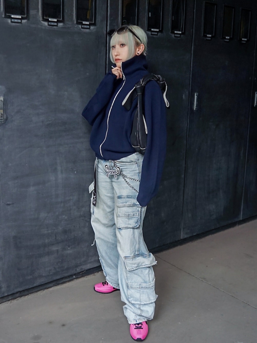 ピンク系のスニーカー、ブラック系のハンドバッグ、ブルー系のカーディガン/ボレロを着用したレディースの春コーディネートの2枚目の写真