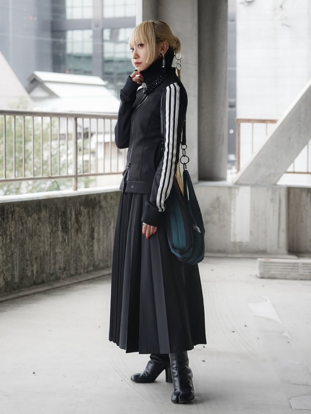 ブラック系のブーツ、ブラック系のジャケット/アウター、ブラック系のスカートを着用したレディースの冬コーディネートの2枚目の写真