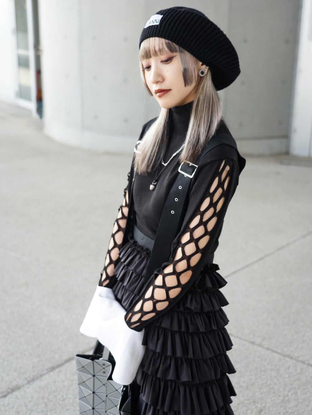 ブラック系のトップス、ブラック系のオールインワン・サロペット、ブラック系のブーツを着用したレディースの春コーディネートの4枚目の写真