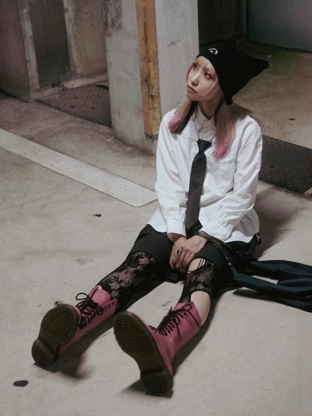 ブラック系のカーゴパンツ、ピンク系のブーツ、ホワイト系のシャツ/ブラウスを着用したレディースの秋コーディネートの2枚目の写真