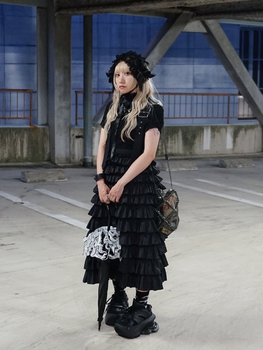 グレー系のショルダーバッグ、ブラック系のTシャツ/カットソー、ブラック系のオールインワン・サロペットを着用したレディースの秋コーディネートの3枚目の写真