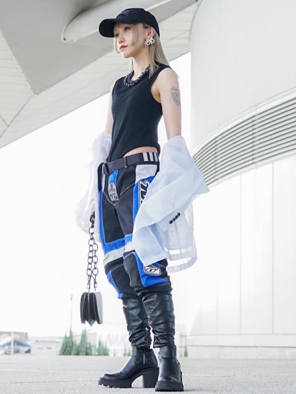 ホワイト系のテーラードジャケット、ブラック系のブーツ、ブラック系のバッグを着用したレディースの秋コーディネートの2枚目の写真