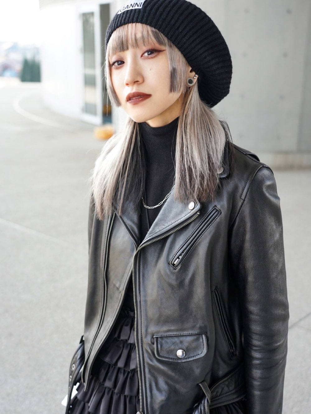 ブラック系のライダースジャケット、ブラック系のオールインワン・サロペット、ブラック系のトップスを着用したレディースの春コーディネートの3枚目の写真