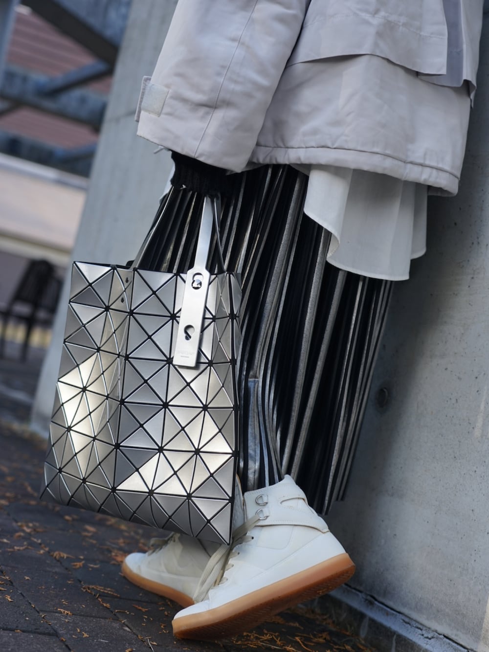 ホワイト系のダウンジャケット/コート、シルバー系のトートバッグ、ホワイト系のスニーカーを着用したレディースの冬コーディネートの3枚目の写真