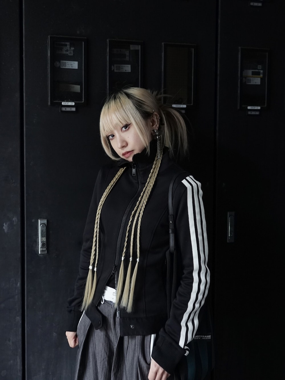 グレー系のスラックス、ブラック系のジャケット/アウター、シルバー系のスニーカーを着用したレディースの冬コーディネートの2枚目の写真