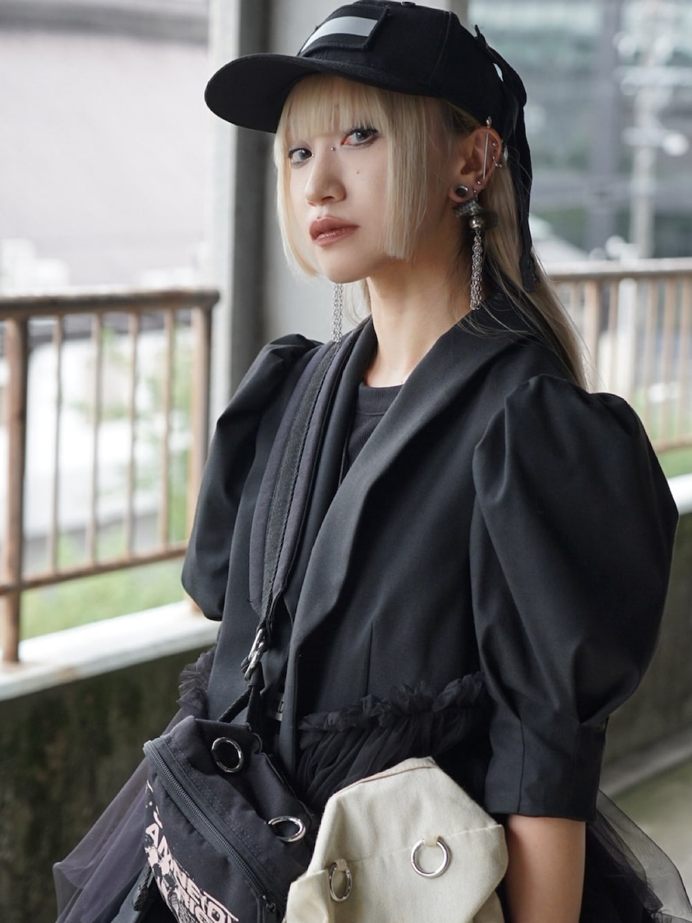 ブラック系のボディバッグ/ウエストポーチ、ブラック系のスニーカー、ブラック系のジャケット/アウターを着用したレディースの夏コーディネートの4枚目の写真