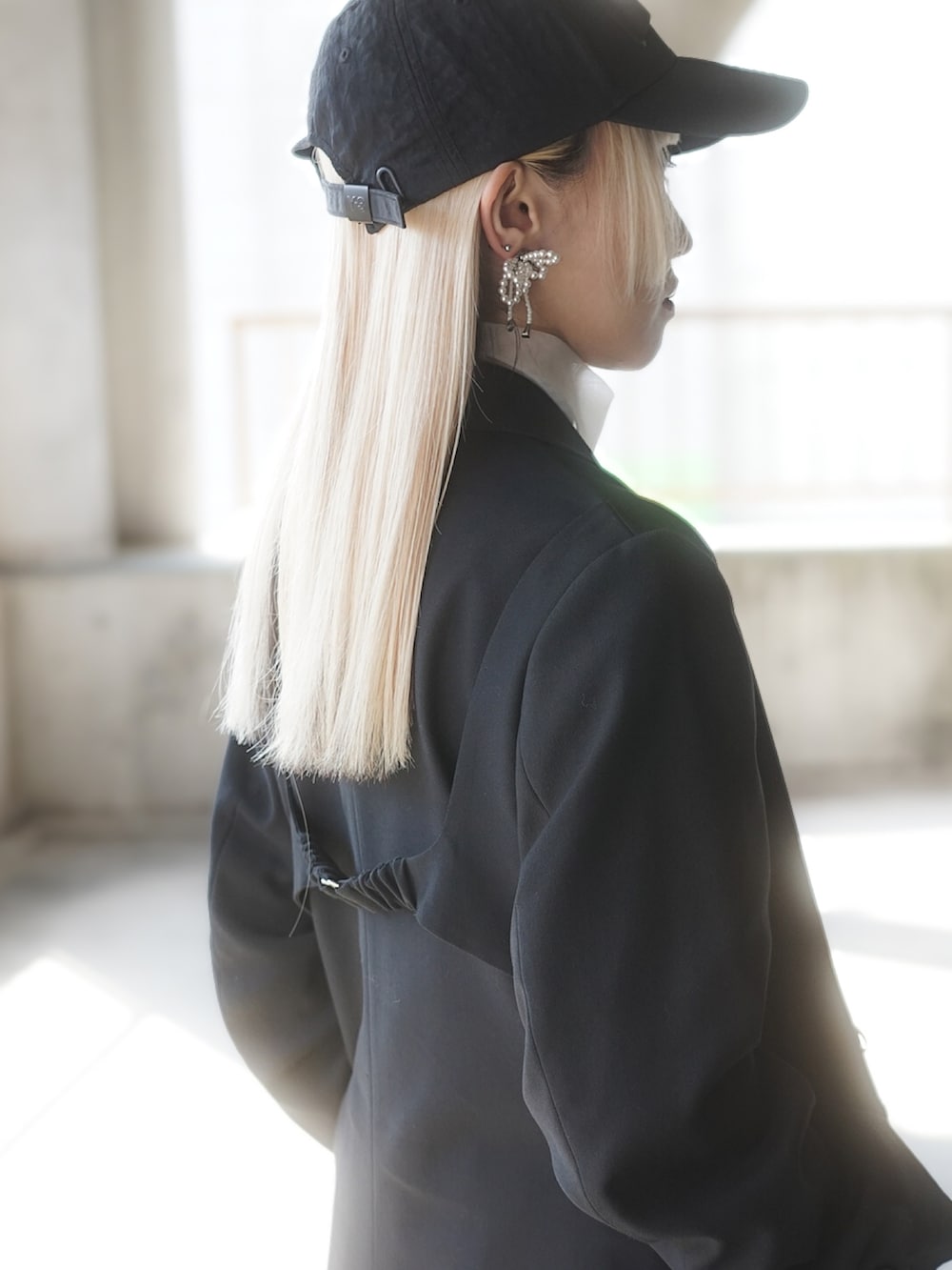 ホワイト系のTシャツ/カットソー、ブラック系のテーラードジャケット、ブラック系のスカートを着用したレディースの春コーディネートの3枚目の写真