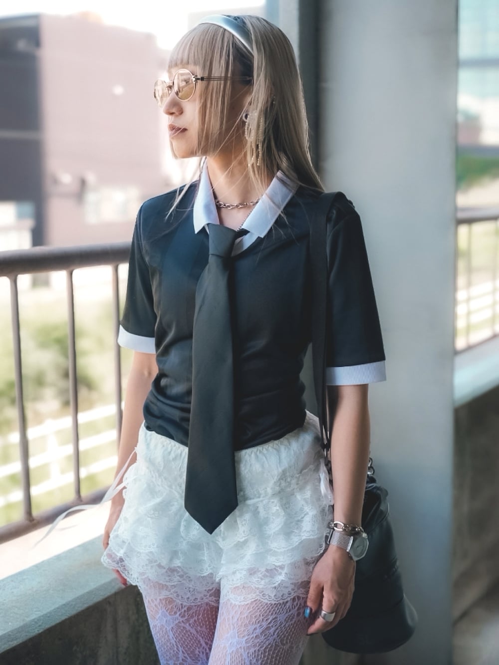 ブラック系のトップス、ピンク系のブーツ、ブラック系のショルダーバッグを着用したレディースの夏コーディネートの4枚目の写真