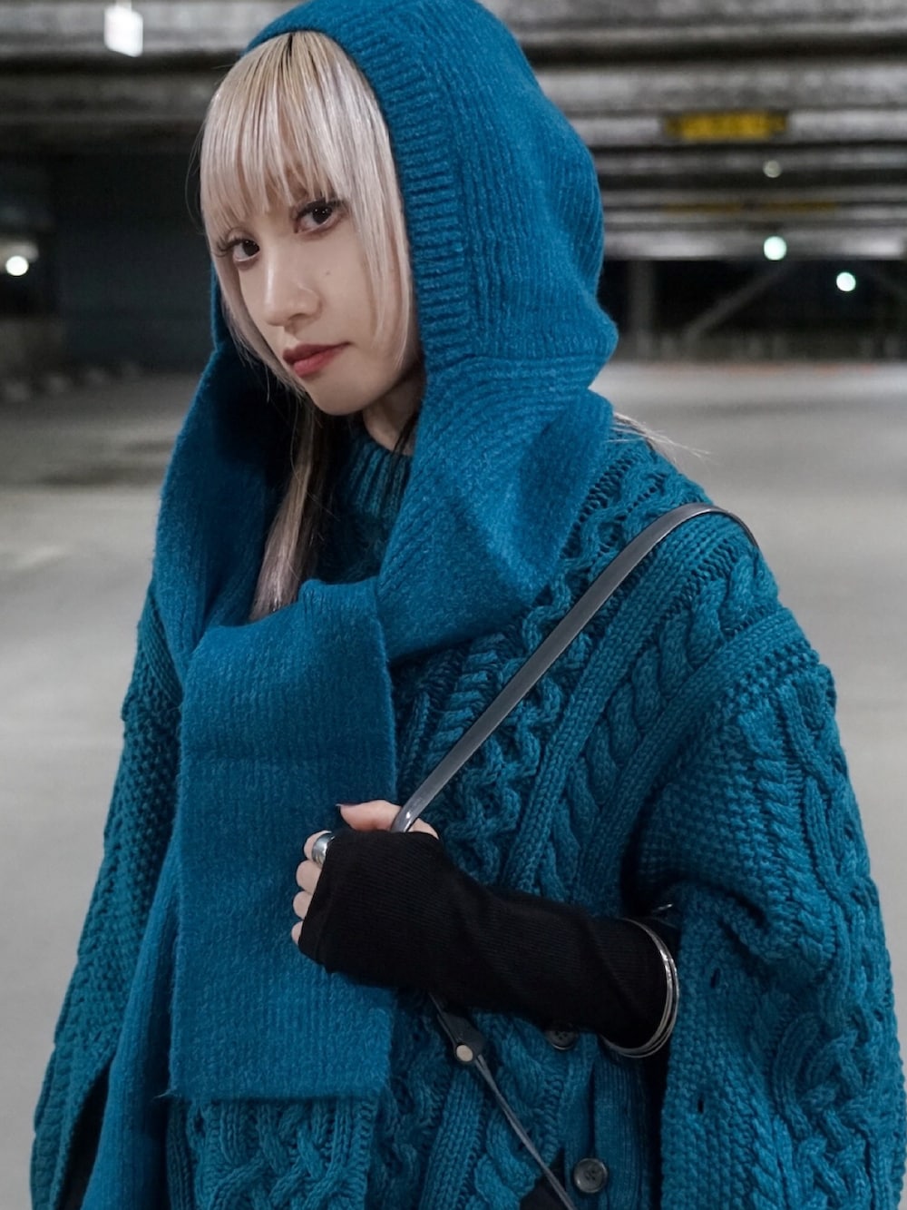 ブラック系のスカート、グレー系のショルダーバッグ、ブルー系のニット/セーターを着用したレディースの秋コーディネートの3枚目の写真