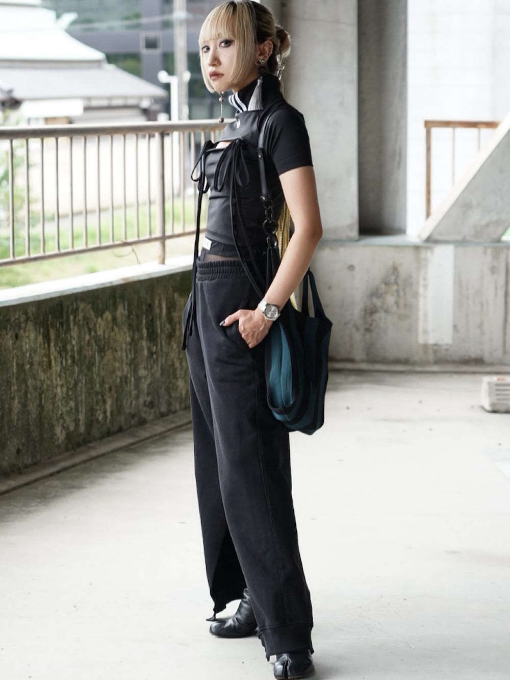 ブラック系のTシャツ/カットソー、ブラック系のスウェットパンツ、ブラック系のブーツを着用したレディースの秋コーディネートの2枚目の写真