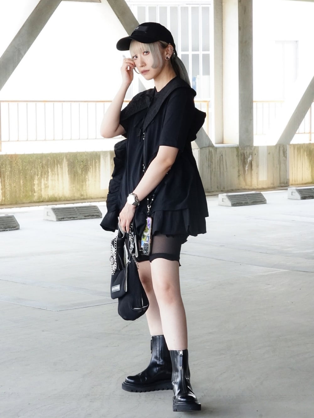 ブラック系のハンドバッグ、ブラック系のブーツ、ブラック系のTシャツ/カットソーを着用したレディースの夏コーディネートの2枚目の写真