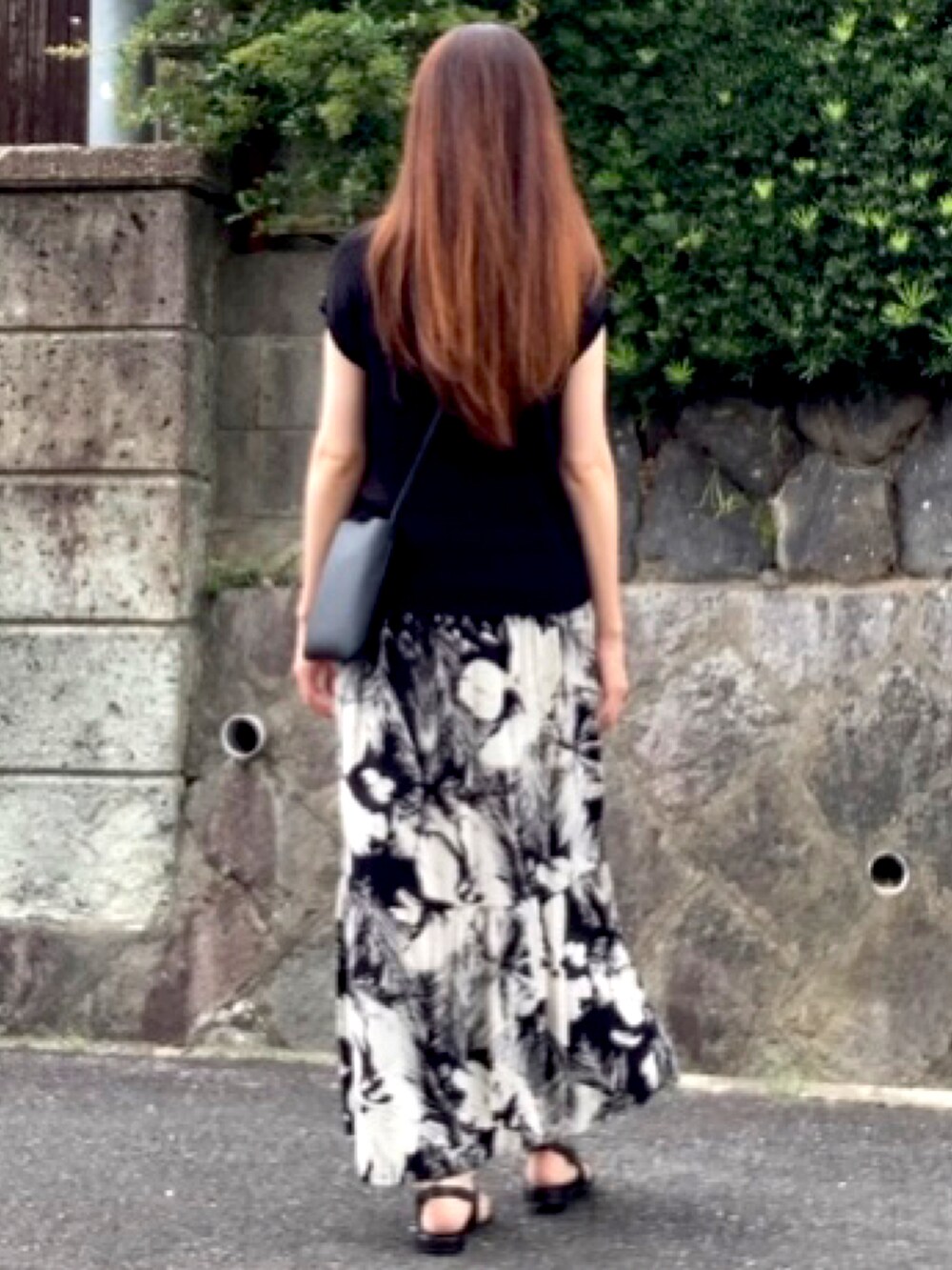 ブラック系のTシャツ/カットソー、ブラック系のスカート、ブラック系のサンダルを着用したレディースの夏コーディネートの2枚目の写真