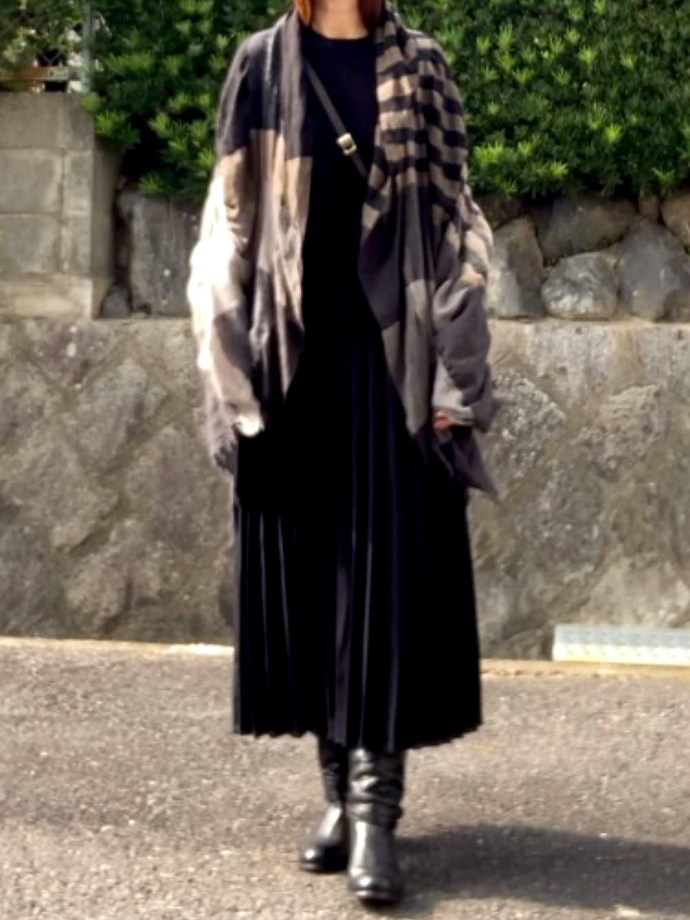 ブラウン系のハンドバッグ、ブラック系のトップス、ブラック系のスカートを着用したレディースの秋コーディネートの2枚目の写真